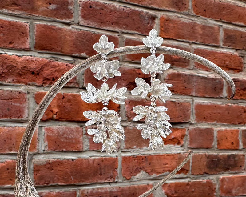 Elegant chandelier earrings featuring intricate cedar flower designs, crafted from sterling silver.