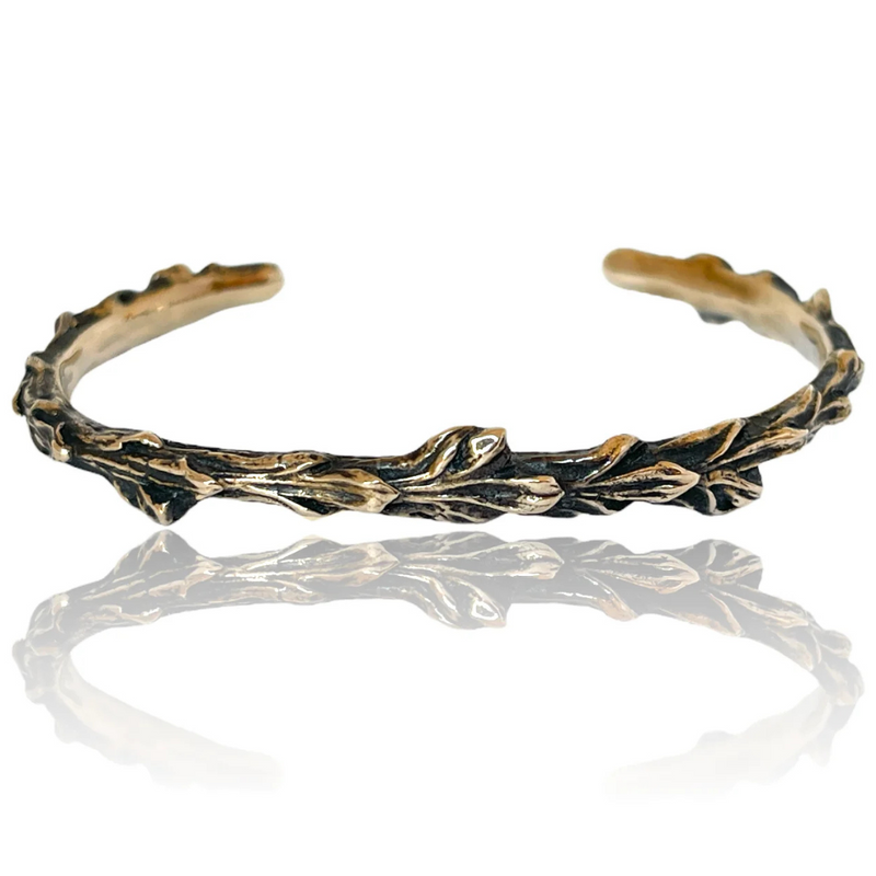 Handcrafted bronze cuff bracelet with a detailed design inspired by deerhorn cedar.